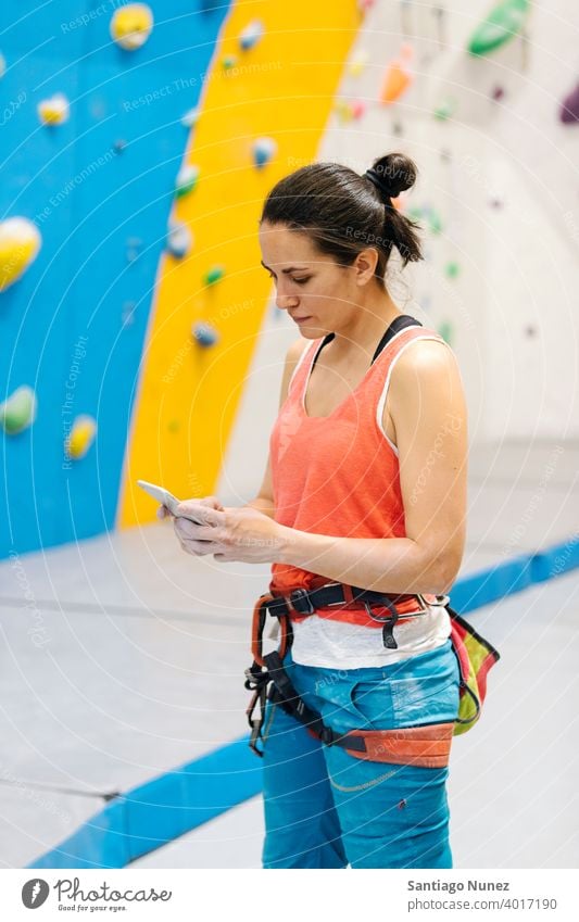 Felskletterer Frau schaut auf Smartphone. Sport Klettern Training Felsen Wand Freizeit Aufsteiger Athlet Technik & Technologie Handy Funktelefon Aktivität