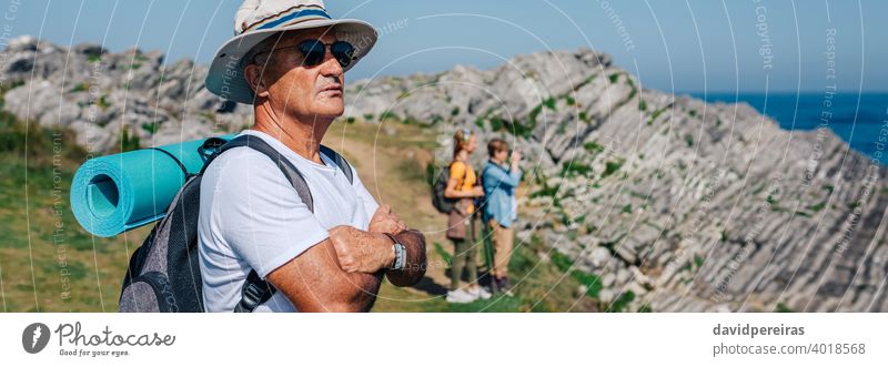 Ein älterer Mann beim Trekking mit Blick auf die Landschaft Wanderer Senior in den Ruhestand getreten Natur Hut Sonnenbrille Transparente Netz Kopfball