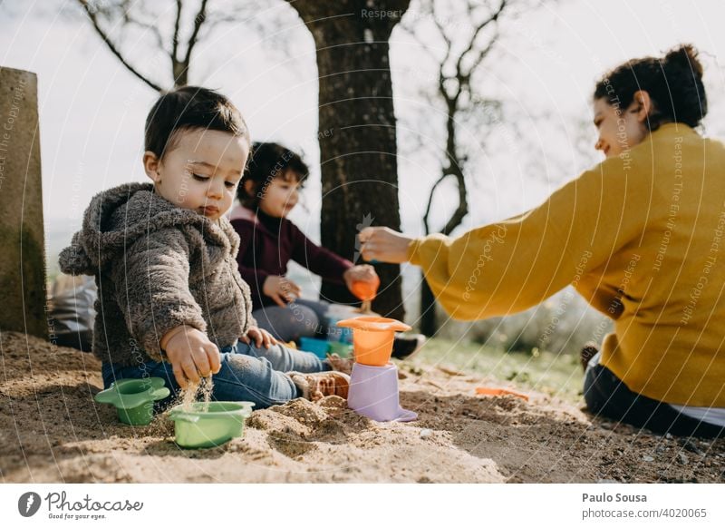 Kind spielt mit Mutter und Schwester im Freien mit Sand Kindheit Familie & Verwandtschaft Kindheitserinnerung Farbfoto Lifestyle Freude Kaukasier Fröhlichkeit