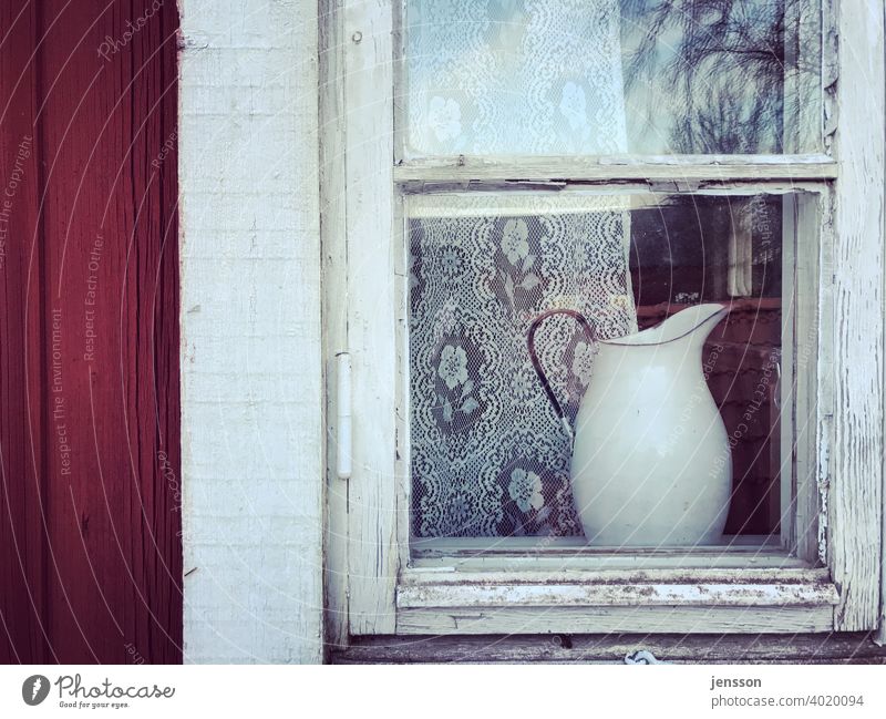 Milchkanne hinter einem Sprossenfenster skandinavisch Schweden Schwedisch Fenster Holz Gardine weiß rot alt verwittert verwittertes Holz Glas Holzhaus