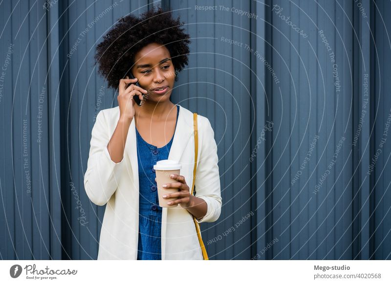 Geschäftsfrau beim Telefonieren im Freien. Afro-Look Business Frau Mobile reden modern Stil brünett Apparatur positiv Konzept Anschluss Anwendung SMS Texten