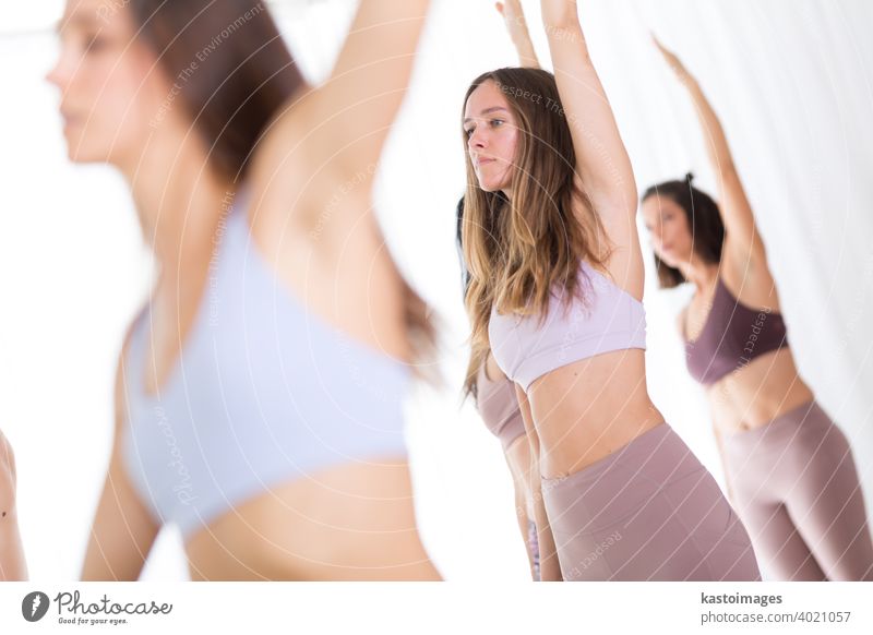 Gruppe von jungen sportlich attraktiven Frauen im Yoga-Studio, üben Yoga-Lektion mit Lehrer, stehend, Stretching und Entspannung nach dem Training. Gesunder aktiver Lebensstil, drinnen in der Turnhalle trainieren