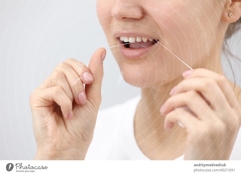 Mundhygiene und Gesundheitsvorsorge. Lächelnde Frau verwenden Zahnseide weiße gesunde Zähne. Hygiene Pflege mündlich dental Frauen Sauberkeit jung Gesicht