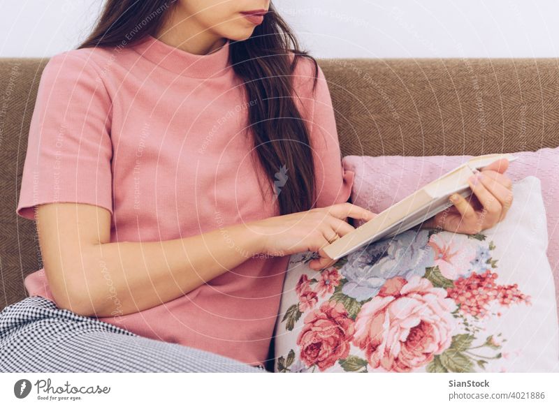 Junge Frau liest ein Buch auf der Couch. Sofa heimwärts Liege Kaukasier Lifestyle Mädchen lesen weiß jung Freizeit lässig hübsch schön Glück Schüler Sitzen