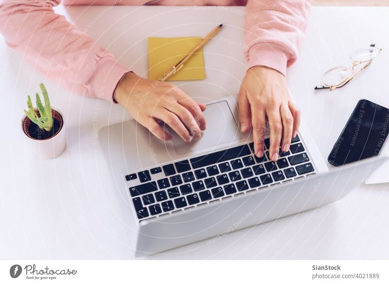 Frau Hände arbeiten am Laptop auf einem weißen Marmor Schreibtisch. Person Arbeit Hand Tisch Murmel Bibliothek hölzern Schreibstift jung Business Top Ansicht