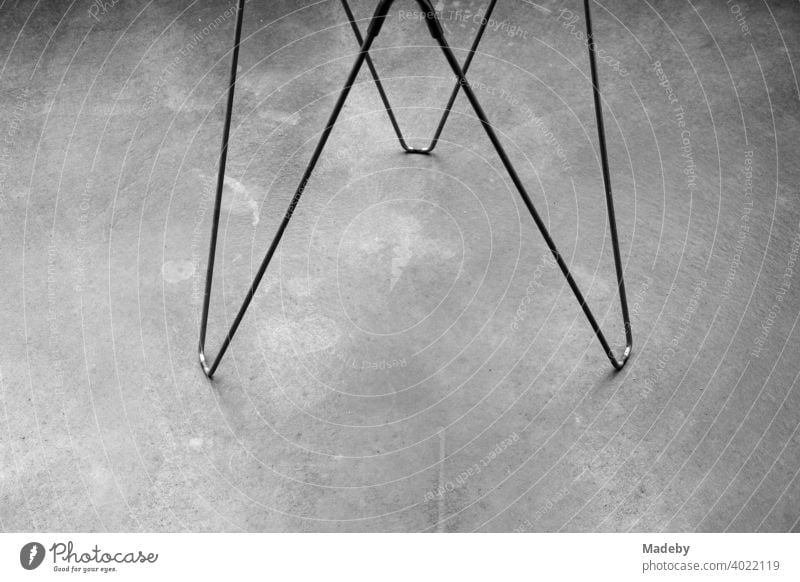 Drahtgestell als Füße eines Beistelltisch auf grauem Betonboden in einer Designerwohnung in Rudersau bei Rottenbuch im Kreis Weilheim-Schongau in Oberbayern, fotografiert in klassischem Schwarzweiß