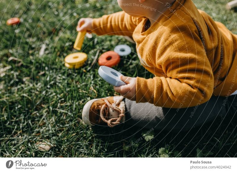 Kind spielt mit Spielzeug im Gras Kindheit unkenntlich Aktivität Freude Glück im Freien wenig Lifestyle Natur Spielen Bildung Kaukasier spielerisch Fröhlichkeit