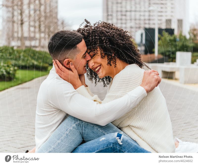 Shallow Fokus eines romantischen jungen Paar umarmt auf einem Bürgersteig unter einem bewölkten Himmel Küssen im Freien Straßenbelag seicht wolkig Mann Frau