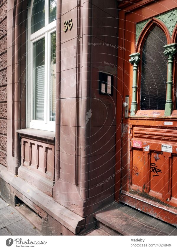 Altbau aus rotem Sandstein mit schöner Holztür im Jugendstil bei Sonnenschein im Nordend von Frankfurt am Main in Hessen Tür Haustür Wohnungstür Eingang