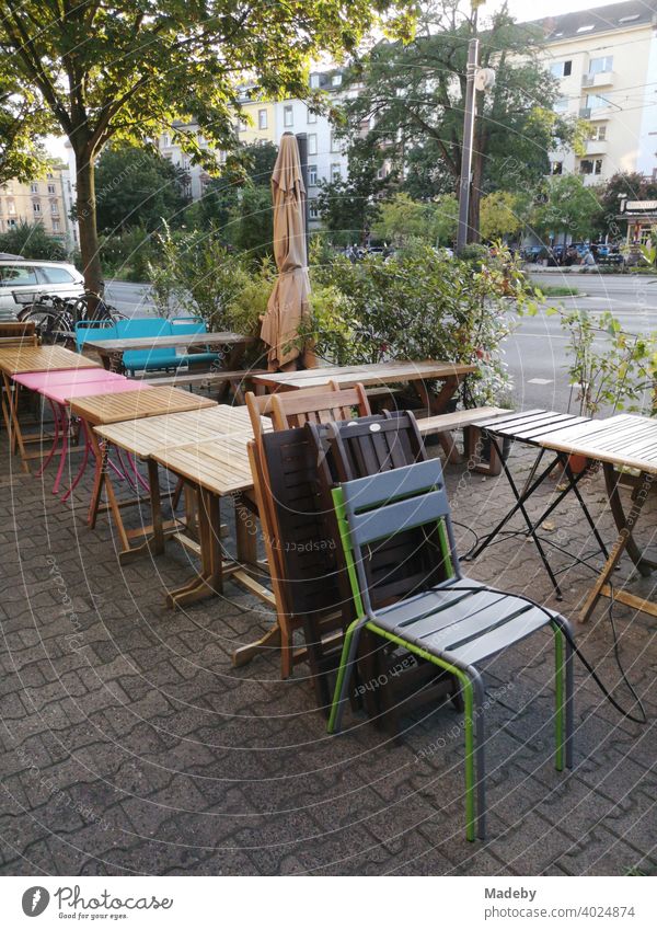 Bistrotische und Stühle auf dem Bürgersteig mit Verbundpflaster vor einem geschlossenen Bistro im Nordend von Frankfurt am Main in Hessen Tisch Stuhl