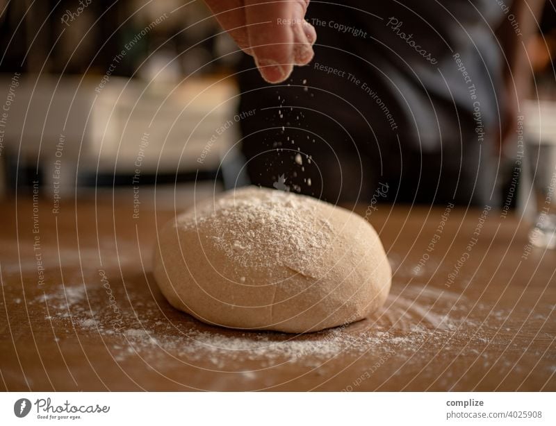 Ein Teig wird auf einem Küchentisch geknetet und mit Mehl bestäubt Teigwaren Pizzateig kneten einstauben selbstgemacht backen Bäckerei Backwaren Brot Brotteig