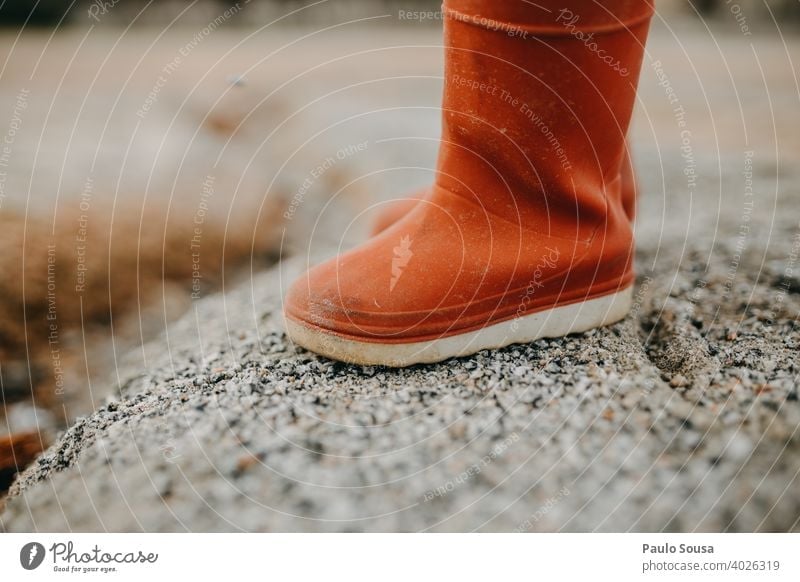 Kind rote Gummistiefel Fuß Schuhe Stiefel Regen Außenaufnahme nass Wetter Wasser dreckig Mensch Freude Beine Textfreiraum Farbfoto schlechtes Wetter Pfütze
