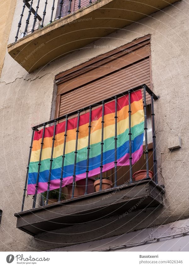 LGBT-Regenbogenflagge an einem Balkon an einer Hausfassade irgendwo in einer Altstadt in Südeuropa schwul lesbisch Homosexualität Liebe Freiheit Lifestyle Fahne