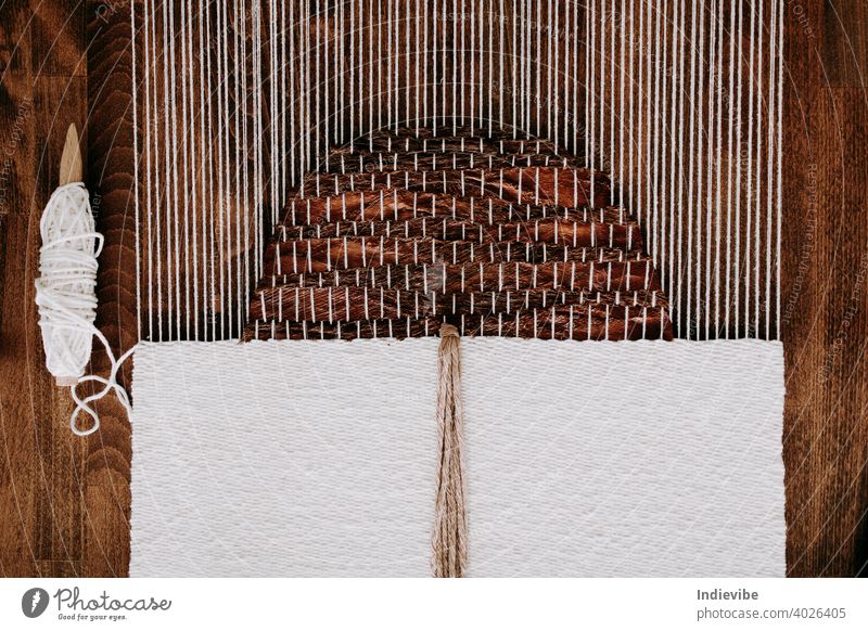 Weberei-Projekt in Arbeit. Unfertiger handgefertigter Wandteppich auf einem Webstuhl. Natürliche Materialien, Kokosnussfaser und Baumwollseil. Seil Garn Faser