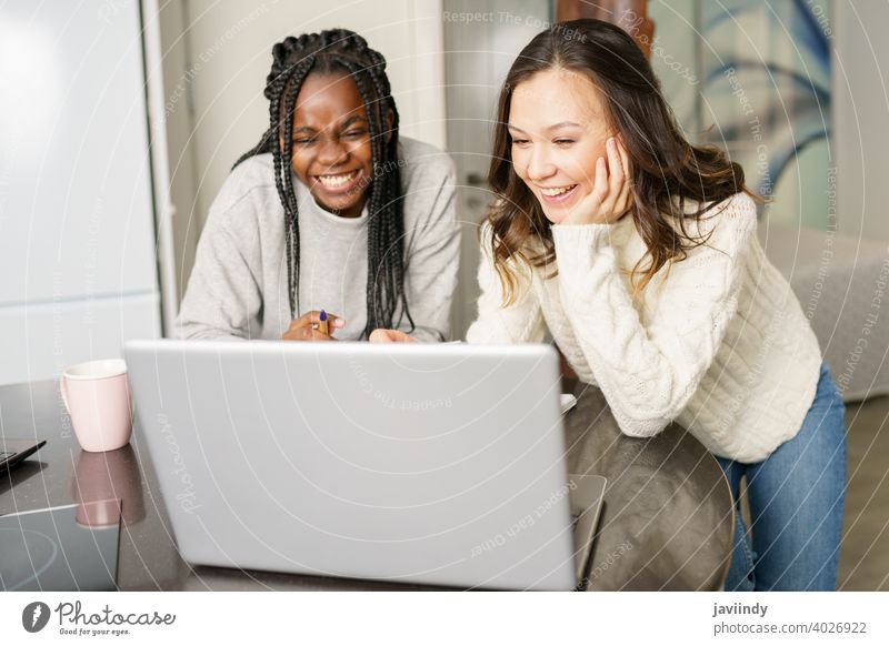 Zwei College-Mädchen studieren gemeinsam zu Hause mit Laptops beim Kaffeetrinken Schüler Frauen multiethnisch heimwärts Computer Hochschule studierend