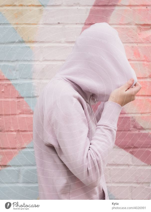 Introvertierter Teenager zieht sich den Kapuzenpulli über den Kopf introvertiert schüchtern Pastell Pastellton pastellfarbene Töne psychische Gesundheit