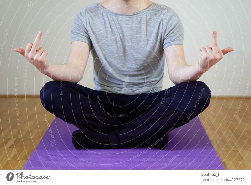 Stressbewältigung - Mann sitzt im Schneidersitz und zeigt beide Mittelfinger Meditation Work-Life-Balance ficken gestresst Yoga mit gekreuzten Beinen Burnout