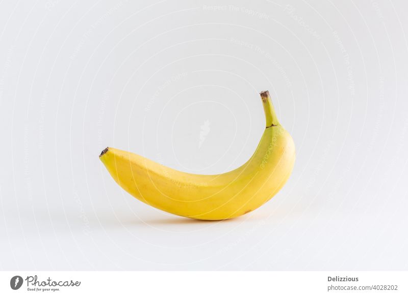 Eine einzelne Banane auf weißem Hintergrund, mit Kopierraum abstrakt appetitlich bananengelb Kalzium Konzept Textfreiraum Dessert Diät essen Essen Energie