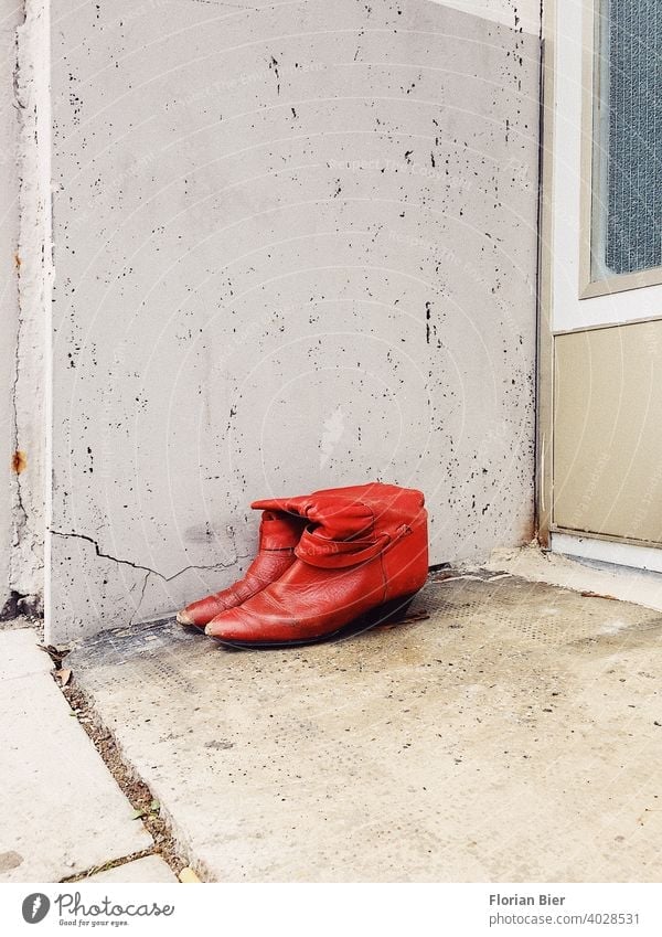 Ein zu Verschenkendes und nicht mehr getragenes Paar rote Damenstiefel abgestellt vor einem Hauseingang Schuhe Stiefel Damenschuhe damenstiefel stiefeletten