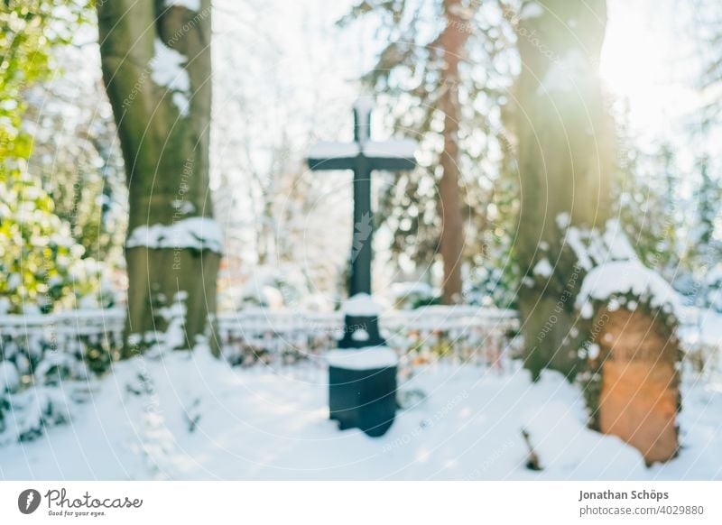 Grab auf Friedhof im Winter bei Schnee Tod und Ewigkeit Abschied Beerdigung Bokeh Christentum Coronatote Coronawinter Gebet Gedenken Gegenlicht Glaube Gott
