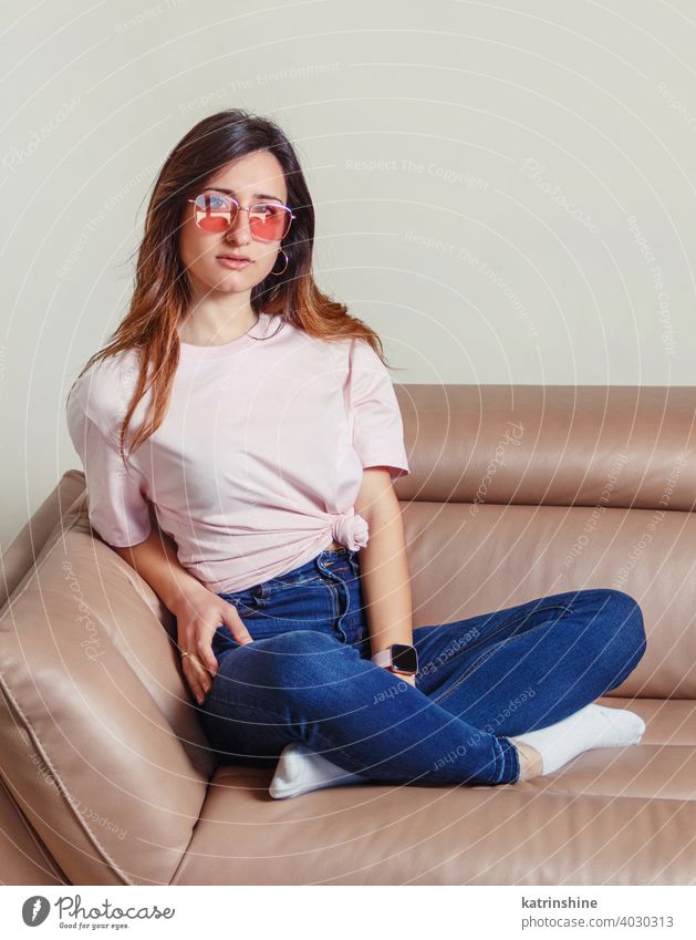 Junge Frauen sitzen auf dem Sofa zu Hause jung anhaben Attrappe T-Shirt Sonnenbrille Lifestyle Jeanshose Brille im Innenbereich sich[Akk] entspannen lange Haare