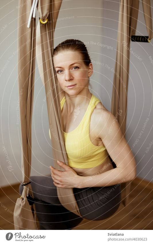 Ein junges Mädchen entspannt sich nach einem Yoga-Workout und sitzt in einer Hängematte für Anti-Schwerkraft-Luft-Yoga. Harmonie, Achtsamkeit und ein gesunder Lebensstil