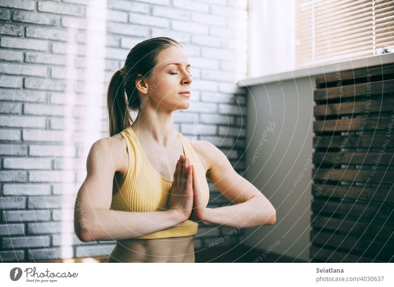Ein blondes Mädchen ruht sich nach einem Fitnesskurs aus und meditiert. Das Konzept von Sport und einem gesunden Lebensstil. Yoga, Meditation meditierend jung