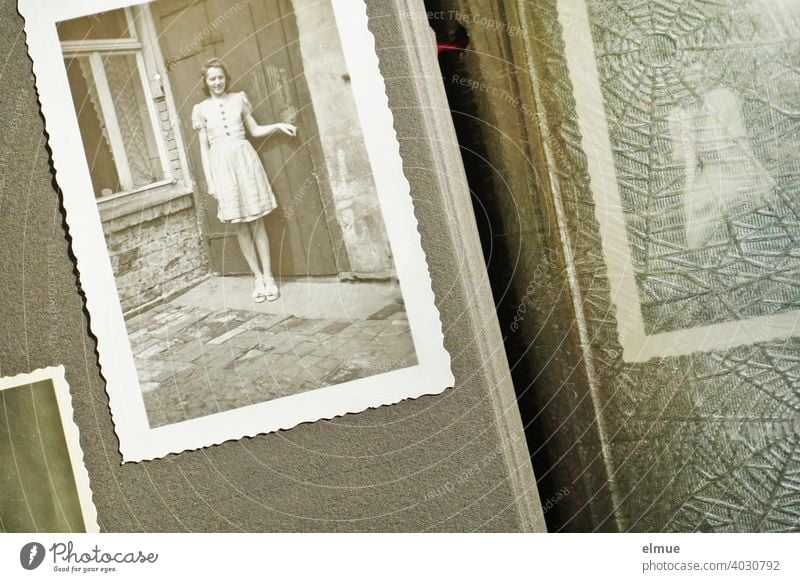 Blick in ein altes Fotoalbum auf ein Schwarz-Weiß-Foto aus den 1940er Jahren mit Büttenrand, eine junge Frau zeigend / Erinnerungen / analoge Fotografie