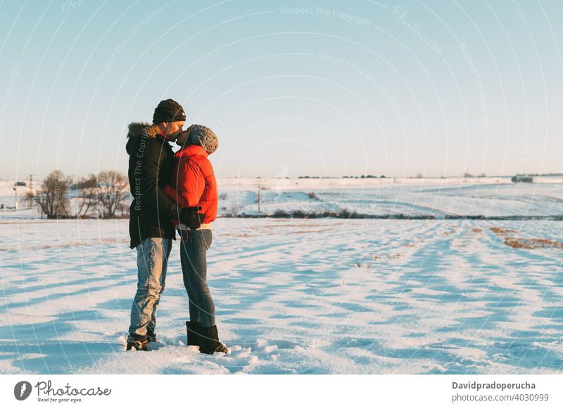 Paar küssen in verschneiten Feld Kuss Winter Schnee Landschaft Liebe romantisch Zusammensein Partnerschaft Umarmung Zuneigung Umarmen amourös Angebot Bonden