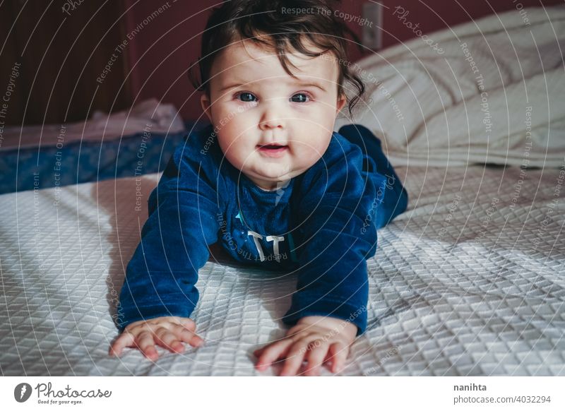 Kleines Baby in Blau liegt auf einem Bett Säuglingsalter niedlich lieblich Mädchen Schlafzimmer heimwärts Familie bezaubernd blau Pyjama spielerisch Gesicht