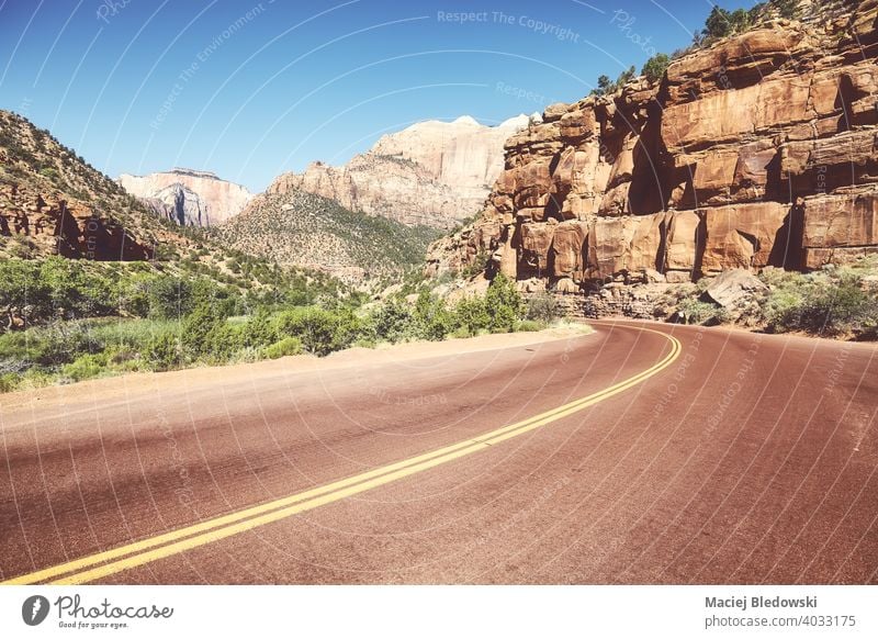 Asphaltstraße im Zion National Park, Retro-Farbtonung angewendet, Utah, USA. Straße Autobahn leer Tal reisen Ausflug retro Natur Landschaft Berge u. Gebirge