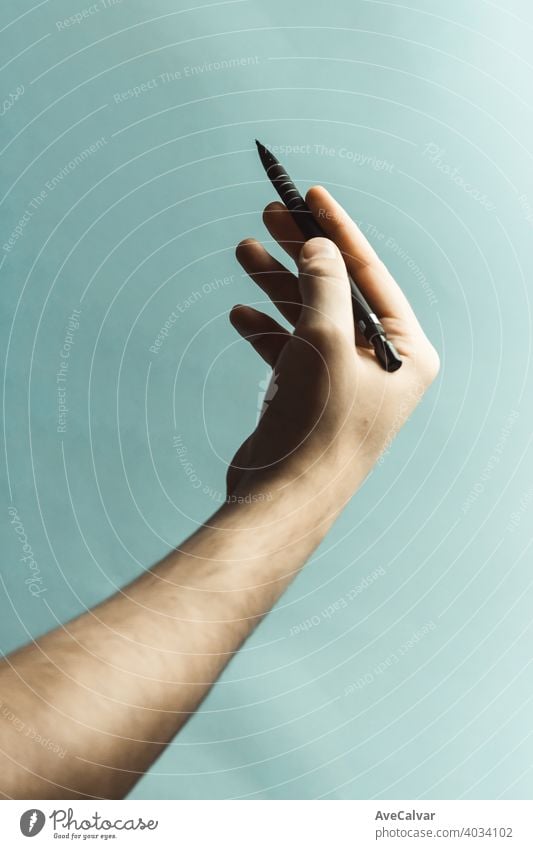 Eine junge Hand, die einen Druckbleistift über einen pastellblauen Hintergrund mit tiefen Schatten ergreift Bleistift Büro Design Schreibstift Papier Bildung