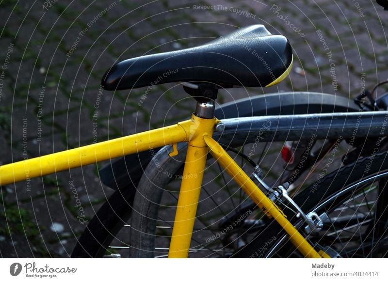 Rennrad mit gelbem Rahmen und schmalem Sattel am Abend an der Hanauer Landstraße im Ostend von Frankfurt am Main in Hessen Fahrrad Rad Gelb Leuchtfarbe Rahmenb