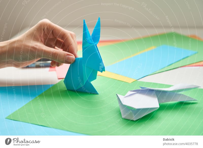 DIY-Konzept. Frau machen Origami Ostern Kaninchen aus Farbe Papier. Origami Unterricht Hase Prozess Hand Hobby handgefertigt Kunst Handwerk Hintergrund
