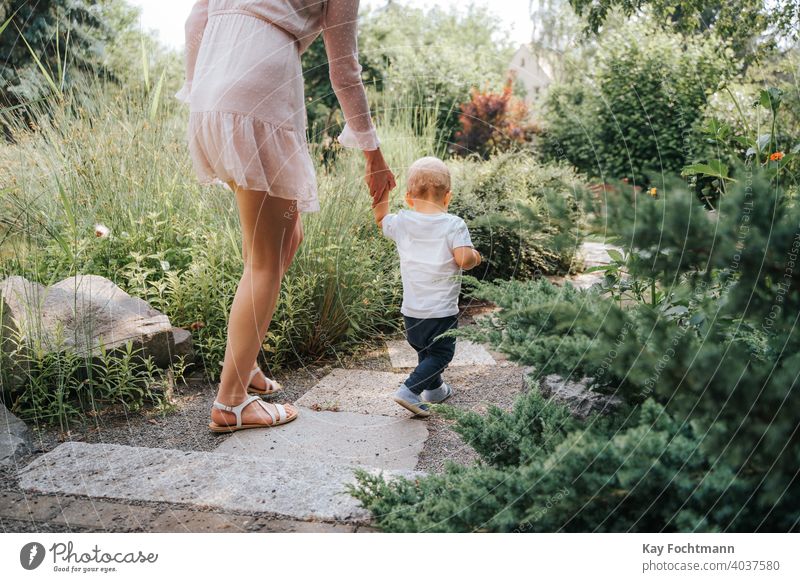 Kleinkind, das mit Hilfe seiner Mutter im Freien laufen lernt bezaubernd Baby Bonden Junge Kind Kindheit krabbeln kriechend niedlich Gefühle erkunden erkundend