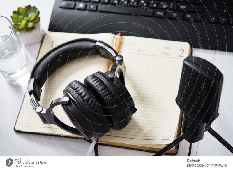 Mikrofon und Kopfhörer auf dem Tisch, Ansicht von oben. Radio-Podcast-Arbeitsplatz Audio online Technik & Technologie Draufsicht Keyboard abgelegen Bildung