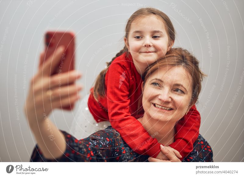 Mutter mit ihrer kleinen Tochter machen Videoanruf mit Handy. Frau und kleines Mädchen im Gespräch mit Verwandten. Fröhliche Familie mit Spaß nehmen selfie Foto mit Smartphone