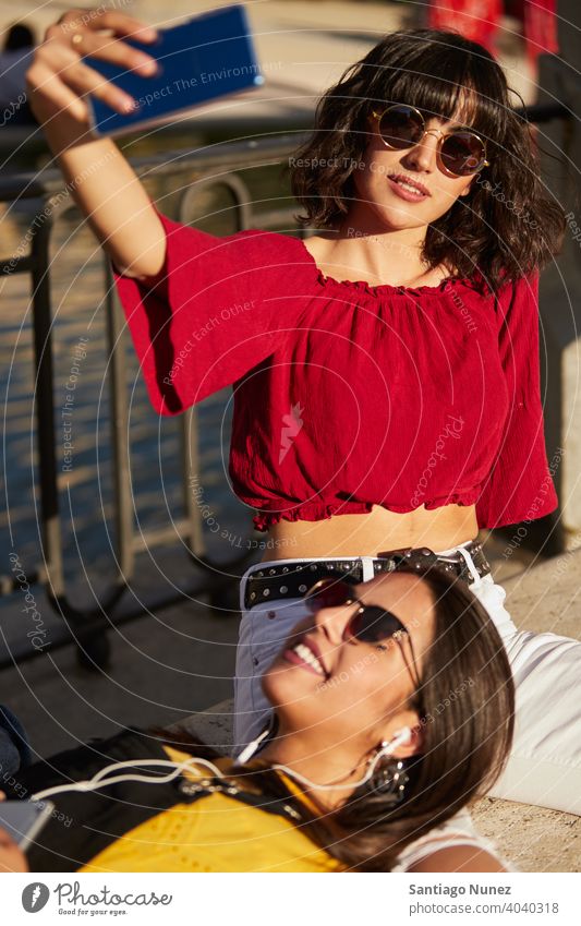 Zwei Teenager-Mädchen sitzen und machen ein Selfie. Madrid jung Menschen Freundschaft Freunde Lifestyle schön Spaß Glück Zusammensein Freizeit Frau Lächeln