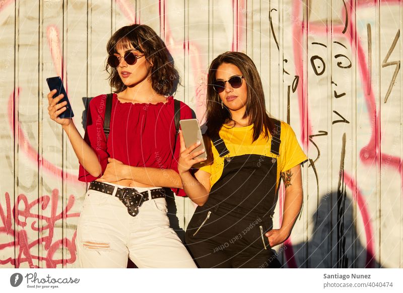 Zwei Teenager-Mädchen stehen und schauen auf ihr Smartphone Madrid jung Menschen Freundschaft Freunde Lifestyle schön Spaß Glück Zusammensein Freizeit Frau