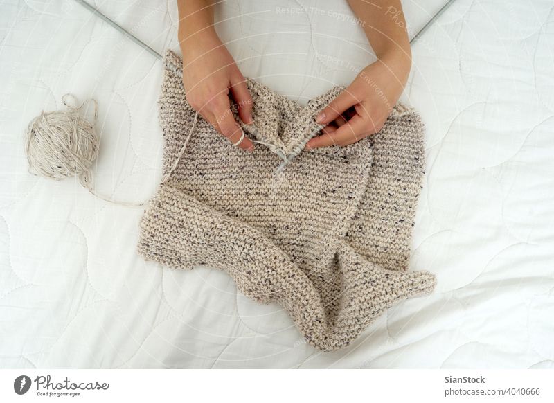 Nahaufnahme der Hände einer jungen Frau, die einen Schal strickt stricken Hand Wolle Handwerk Nadel Pullover Muster Mode warm Bekleidung Finger Garn Schnur