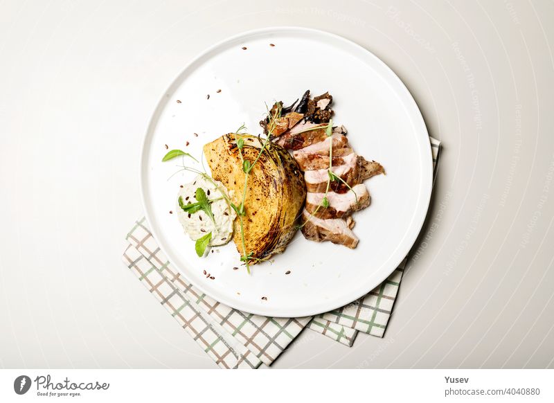 Draufsicht Entenbrust mit Krautsteak mit Käsesauce. Leckeres Restaurant Gericht auf einem runden Teller auf einer karierten Serviette Brust Kohlgewächse Steak