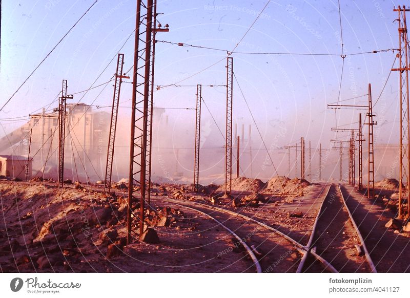 Bahnschienen auf Fabrikgelände in der Wüste Schienen fabrik industriegebiet Industrie Elektrizität Leitung Kabel Technik & Technologie Hochspannungsleitung