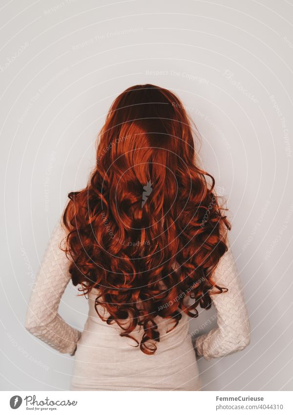 Rückansicht einer Frau mit langen roten lockigen Haaren in hautfarbenem Pullover Schlank lockiges haar feminin gepflegt glänzend Haare & Frisuren Junge Frau