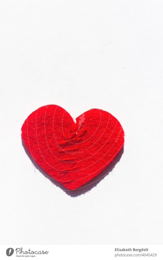 zusammengenähtes rotes Herz (aus Filz) auf weißem Hintergrund Liebeskummer Herzschmerz Scheidung Hoffnung Trennung Trennungsschmerz Reparieren Schmerz