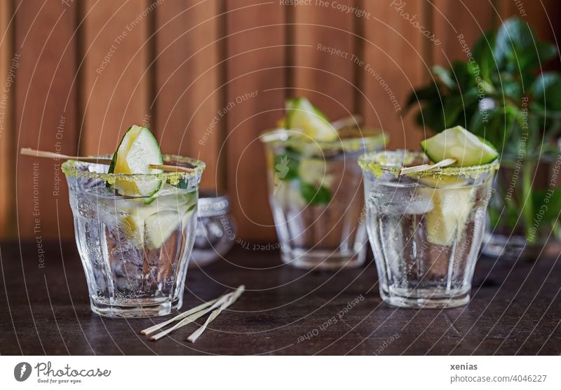 Drei Gläser eisgekühltes aromatisiertes Wasser mit Ananas, Gurke, Pfefferminz und gelbem Zuckerrand stehen zum Genießen bereit Getränk Erfrischungsgetränk Glas
