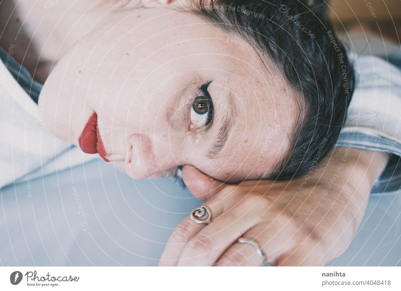 Porträt einer jungen Frau, die ihr Gesicht gegen einen kalten Glastisch lehnt Depression blau traurig mental Gesundheit Psychologie Traurigkeit depressiv weiß