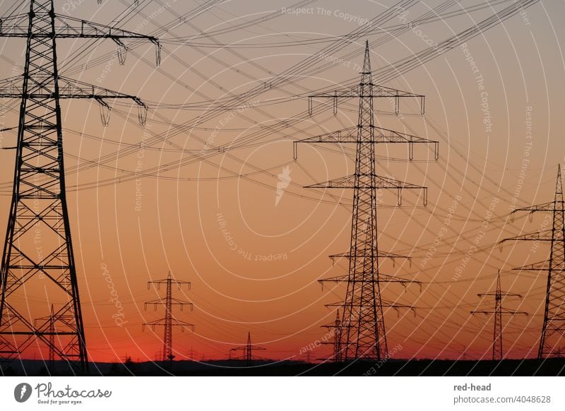 Hochspannungsmasten vor orangerotem Abendhimmel, tiefer Horizont, überkreuzende Leitungen, Masten teilweise angeschnitten Strommast Energie Hochspannungsleitung