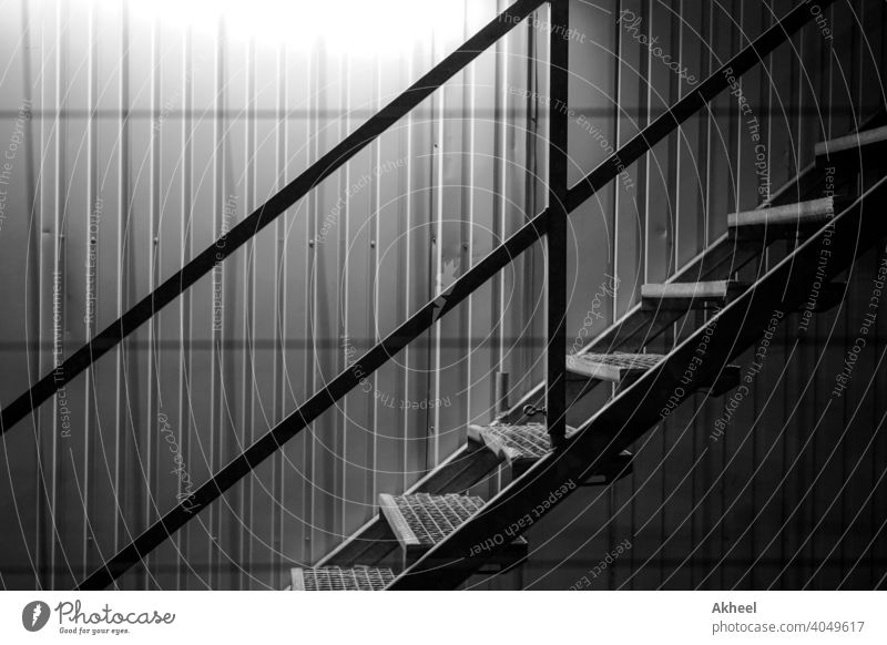 Treppe mit beleuchtetem Hintergrund in einer Baustelle. Schiffscontainer mit Treppe. abstrakt architektonisch Architektur schwarz auf weiß Gebäude Großstadt