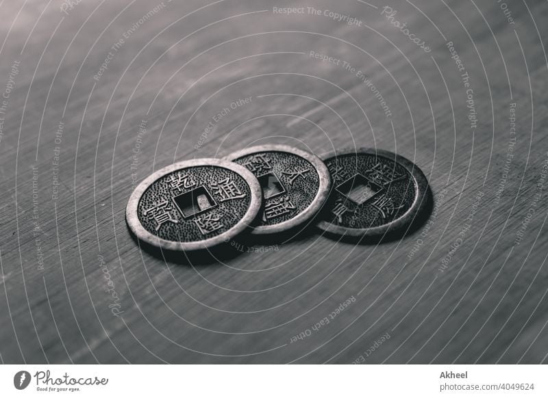 Traditionelle chinesische Münzen, die auf ein Holzbrett gelegt werden. Glückliche chinesische Münzen. Replik der alten Münzen. Antiquität asiatisch Hintergrund