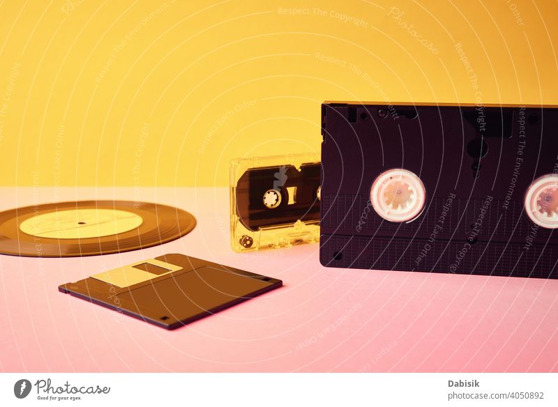 Vinyl-Disc, Floppy-Diskette, VHS und Bandkassette auf gelbem Hintergrund. Retro und Nostalgie Konzept retro Scheibe Kassette Aufzeichnen altehrwürdig Musik